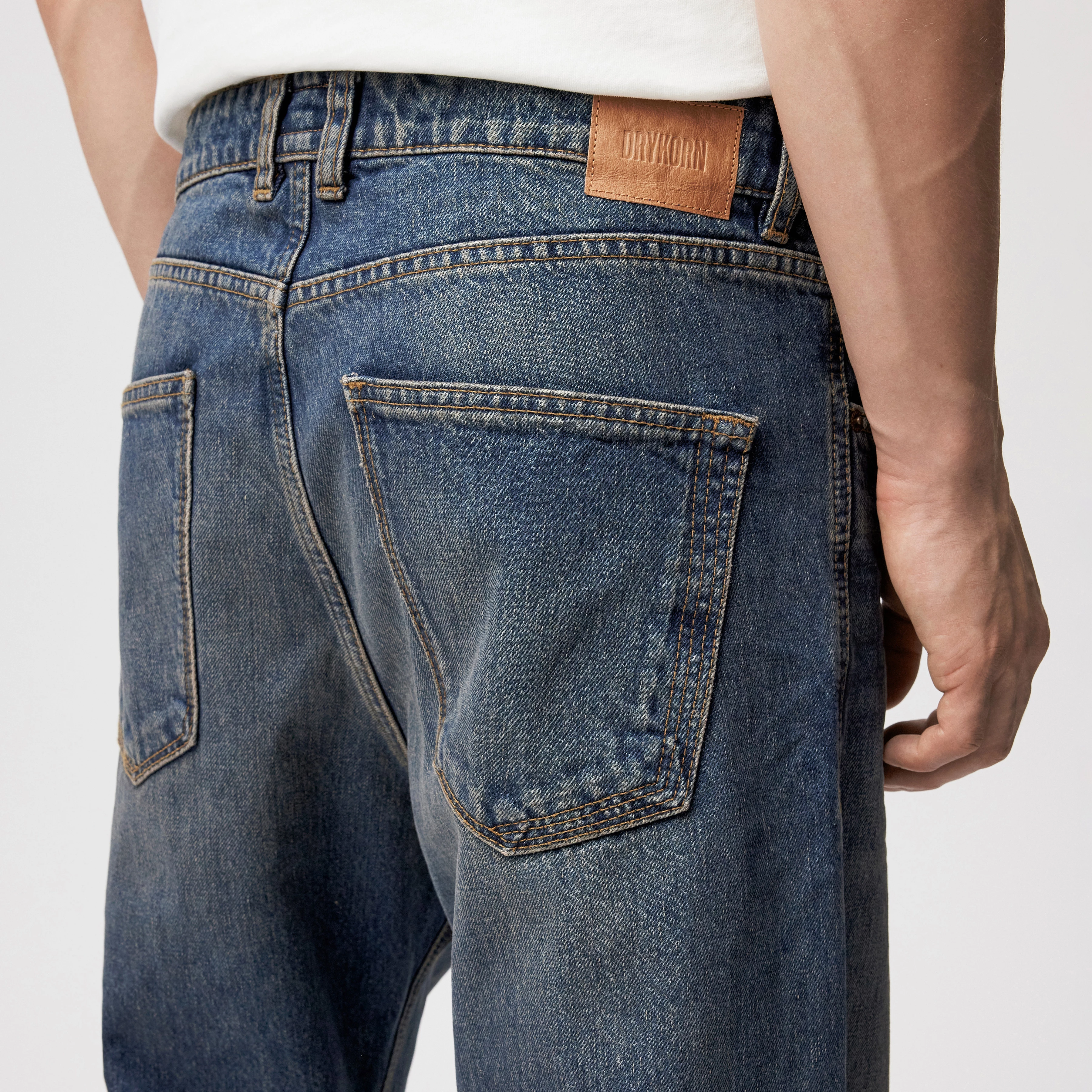 LOWDY - Jeans mit weitem Beinverlauf in Mid-Blue Denim - Herren - blau - Detailansicht am Model