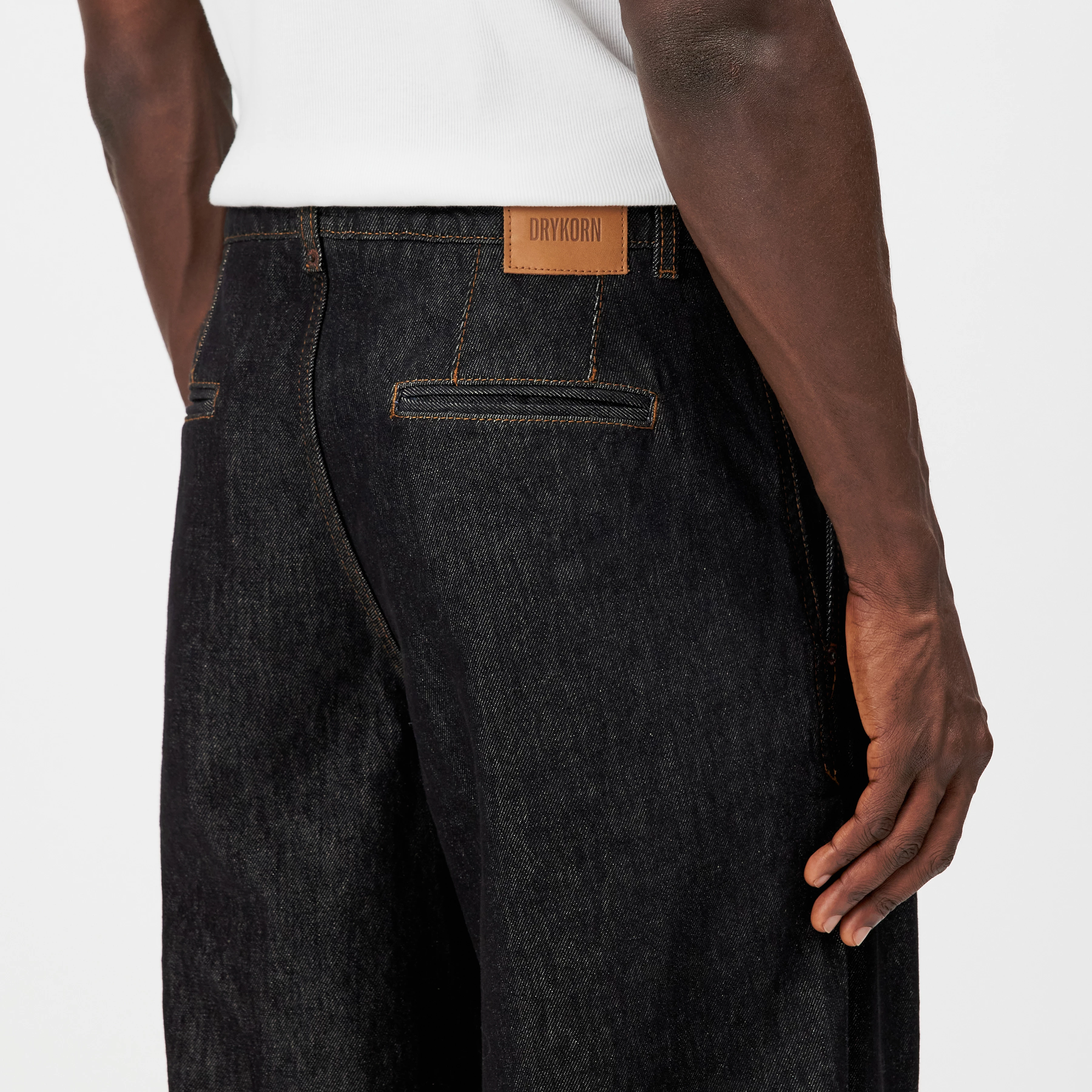 RIKKAD - Wide pleated trousers in dark denim - men - black - Detailansicht am Model
